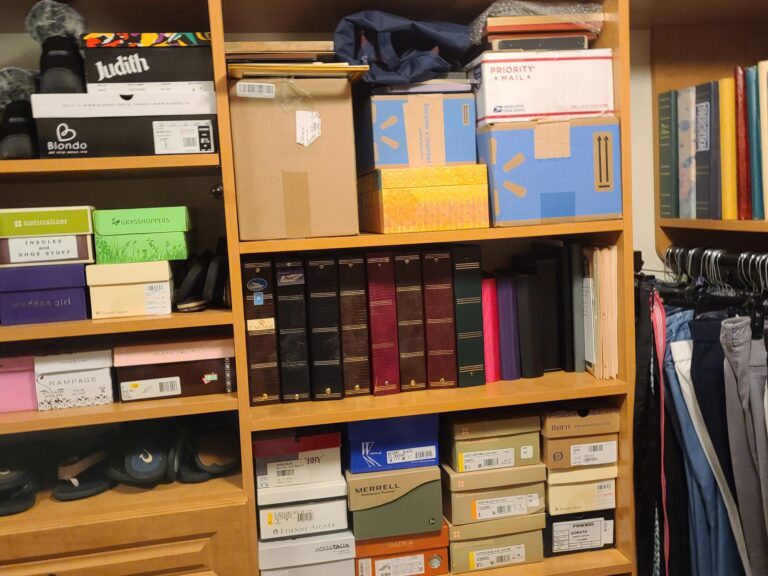 a bookshelf cluttered with boxes and books